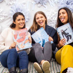 three girls holding magazines